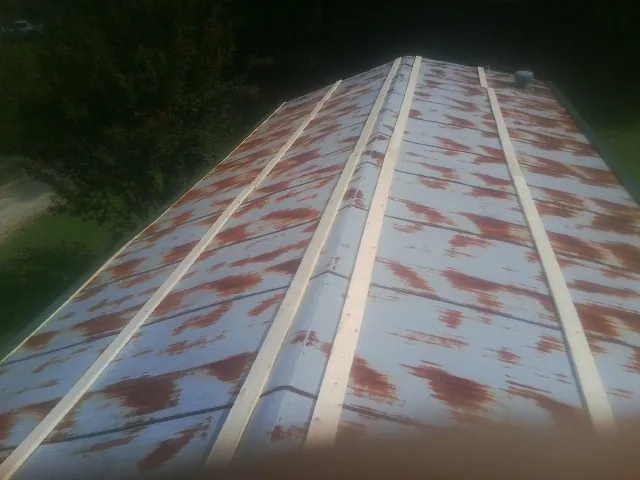 Rusted metal roof panels with new wood purlins before replacement — Storm Damage Roof Repair in Halbur by Roofing Brothers