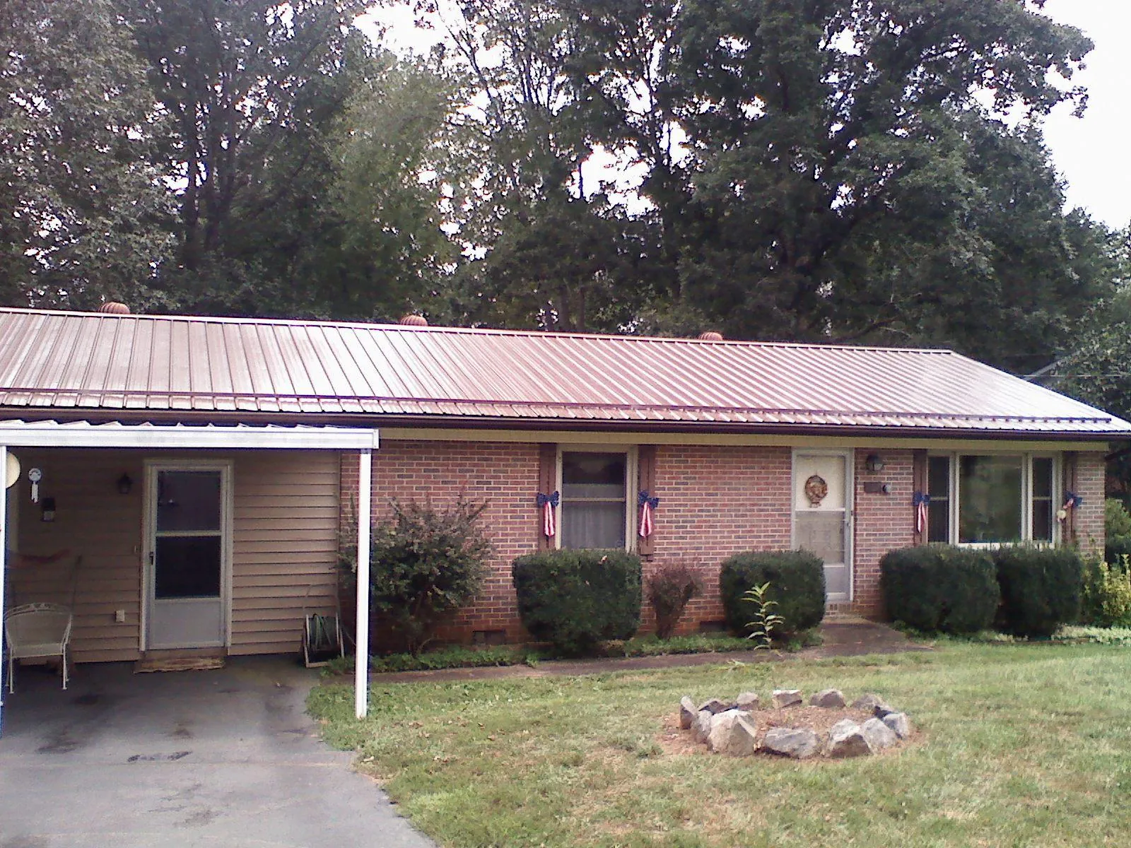 Bronze metal roof and carport on a brick ranch home — Roof Repair work by our crew in Halbur